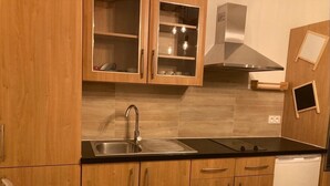 Een moderne keuken met houten kastjes, een roestvrijstalen spoelbak en een ingebouwd fornuis.