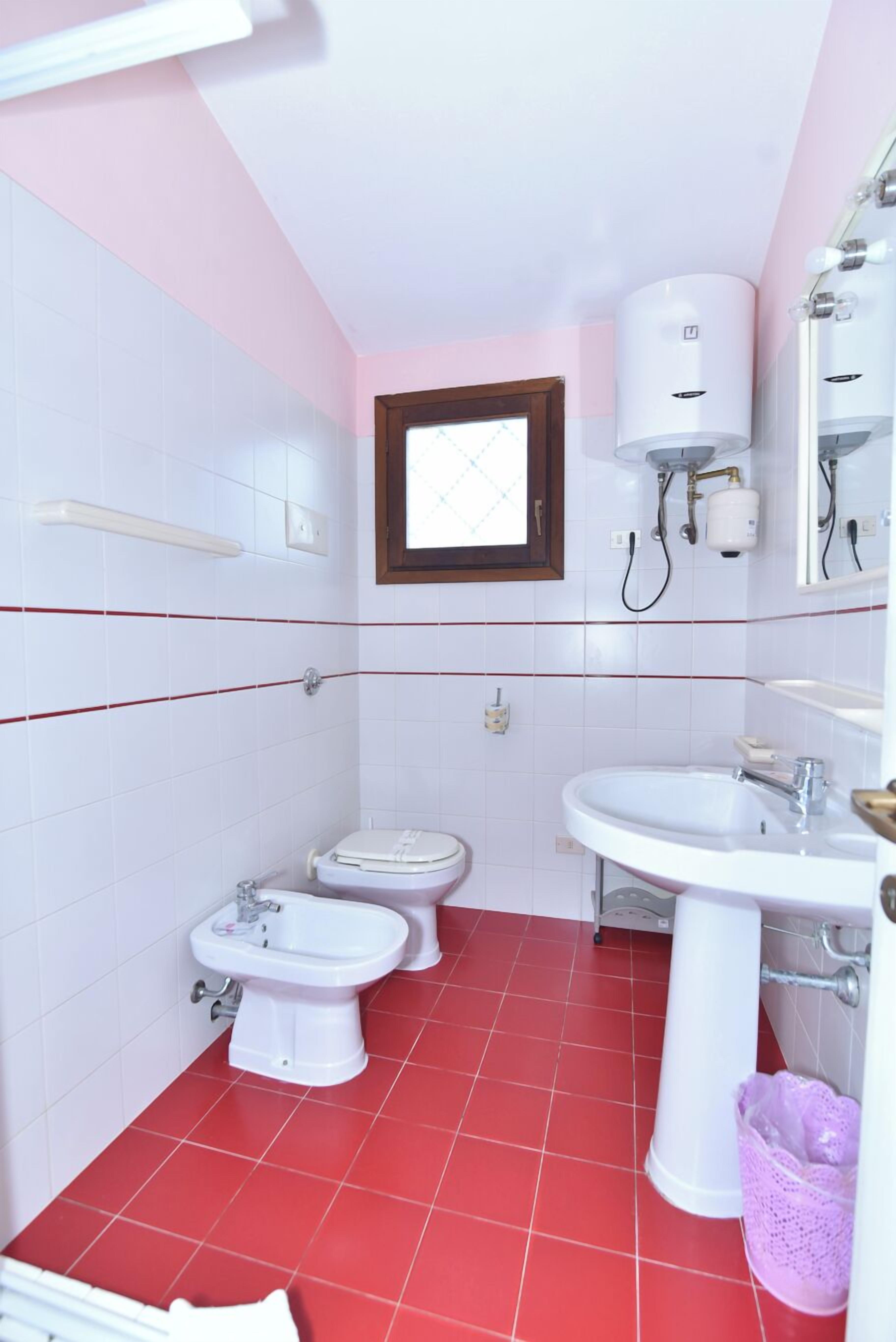 Ein kleines Badezimmer mit Toilette, Bidet und Waschbecken.
