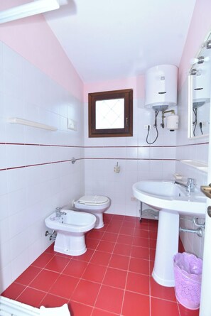 A small bathroom with a toilet, bidet, and sink.