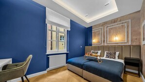 Ein Schlafzimmer mit Bett, Stuhl, Nachttisch und Fenster.