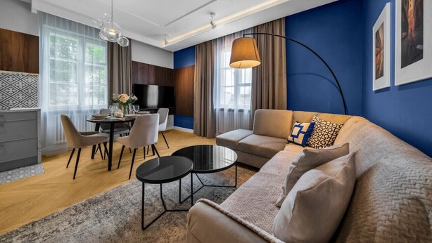 Ein modernes Wohnzimmer mit Sofa, Couchtisch und Essbereich.
