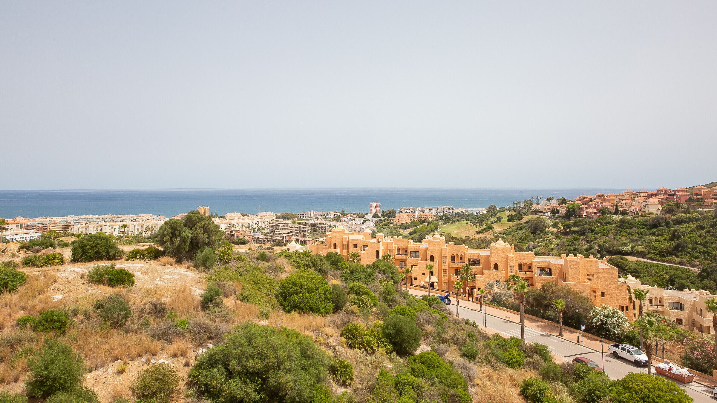 Une ville côtière qui allie une architecture traditionnelle et moderne, offre une vue dégagée sur la mer et présente un paysage vallonné et verdoyant.
