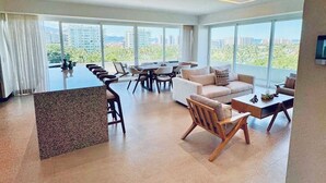 A spacious living area with a central island, a dining table, and seating arrangements. - Luxury Retreat, VGolf. Marina Vallarta. (Puerto Vallarta)