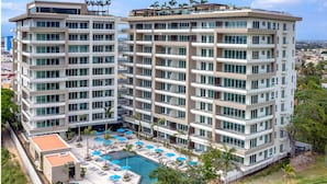 A multi-story hotel with a rooftop pool area, surrounded by greenery and a view of the cityscape. - Luxury Retreat, VGolf. Marina Vallarta. (Puerto Vallarta)