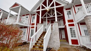 A red and white multi-story building with a central staircase, stone pillars, and balconies.