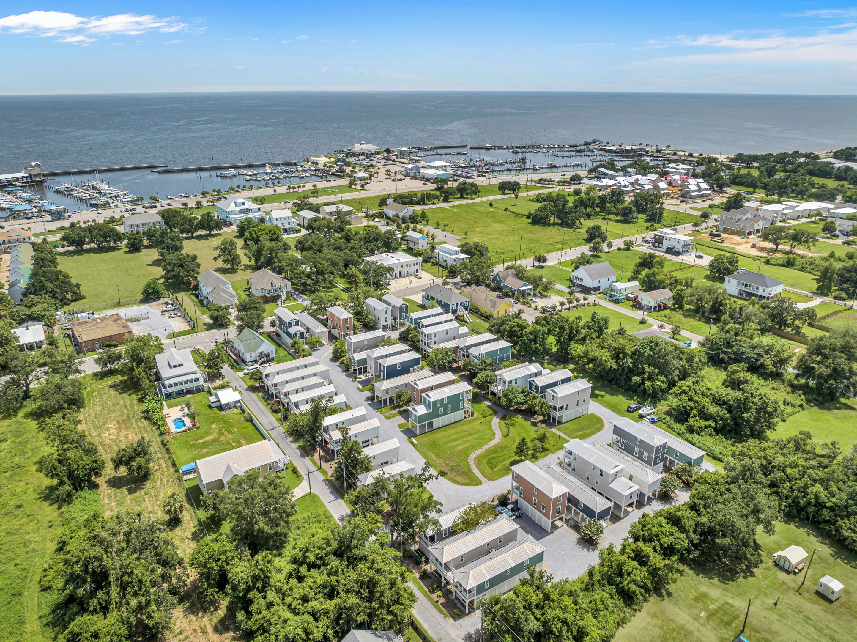 Zona residencial com casas, um porto de iates e uma grande extensão de água ao fundo.