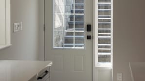 A modern bathroom with a white vanity, a glass shower enclosure, and a built-in towel rack.