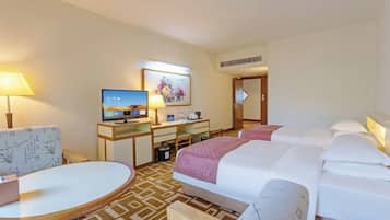 Habitación de hotel con cama, escritorio con computadora, una silla y televisor.