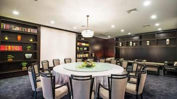 A conference room with a round table, chairs, and bookshelves.