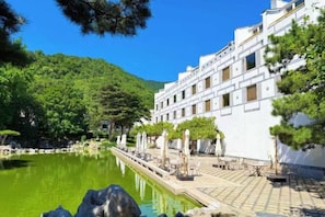 Ett hotell med pool, uteservering och en vacker bergsutsikt.
