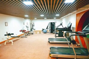 A gym with treadmills, exercise balls, and weight machines. - Fragrant Hill Hotel (Beijing)