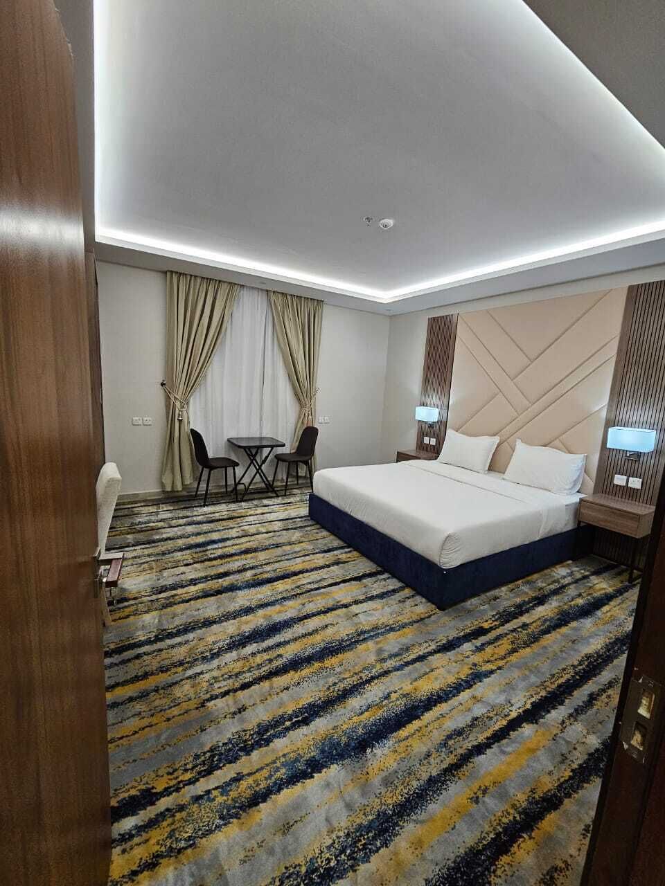 Une chambre d’hôtel comprenant un lit, des tables de chevet, un bureau et une chaise.