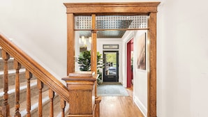 Un escalier en bois, doté d’une rampe, mène à une porte portant l’inscription « 110 ».