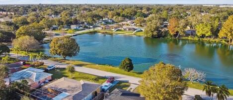 Un quartier résidentiel avec des maisons, un grand lac et un pont.