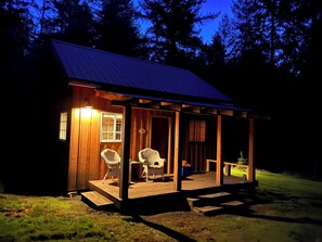 A wooden cabin with a porch, two wicker chairs, and a small table. - Tranquil cabin with WiFi in Brush Prairie (Brush Prairie)