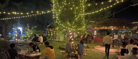 An outdoor dining area with string lights and tables.
