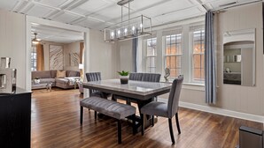 A spacious dining area with a large rectangular table, grey upholstered chairs, and a modern chandelier. - 6BR Springfield Getaway Sleeps 15 Fire Pit & BBQ (Springfield)