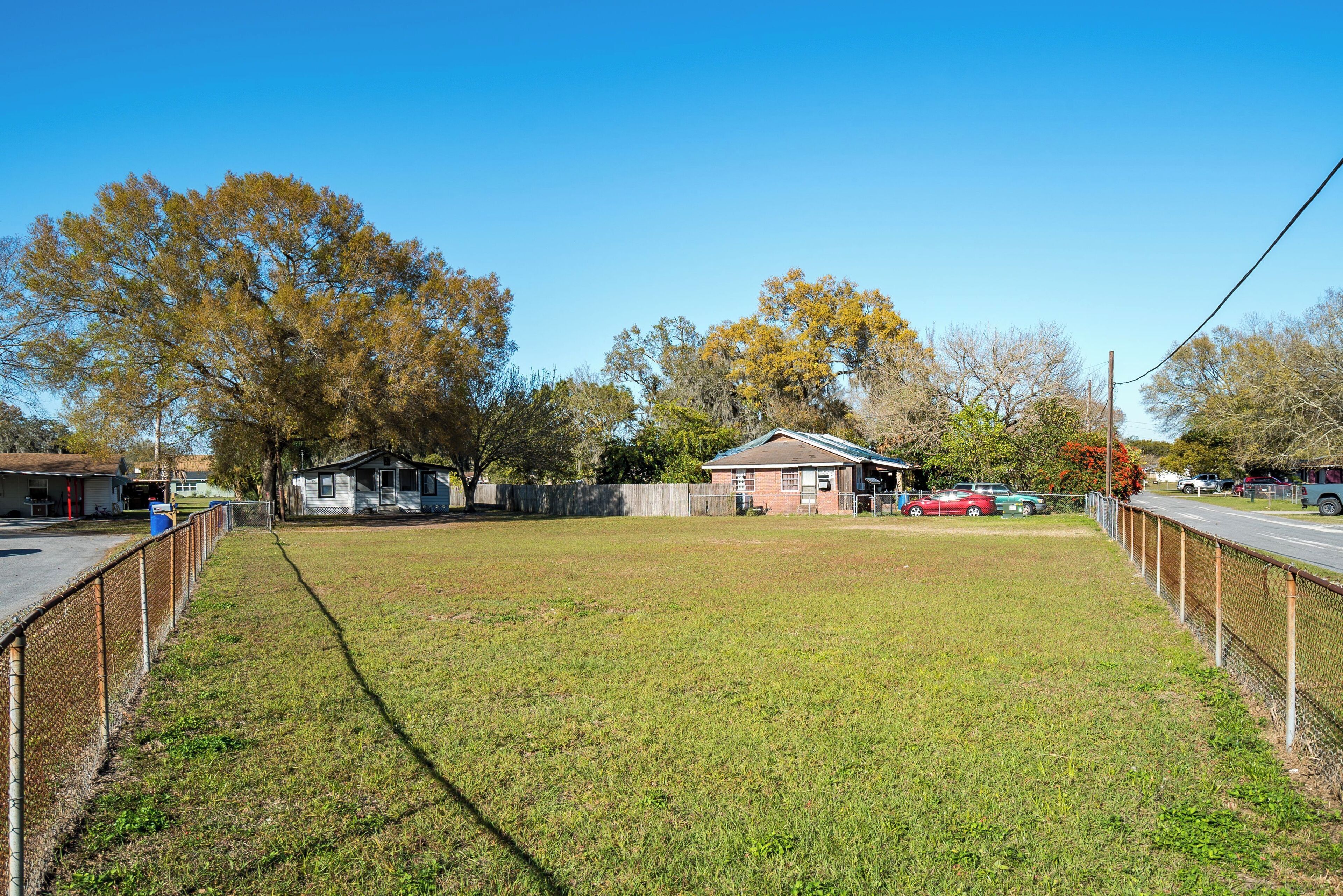 A grassy field with a house and a fence.