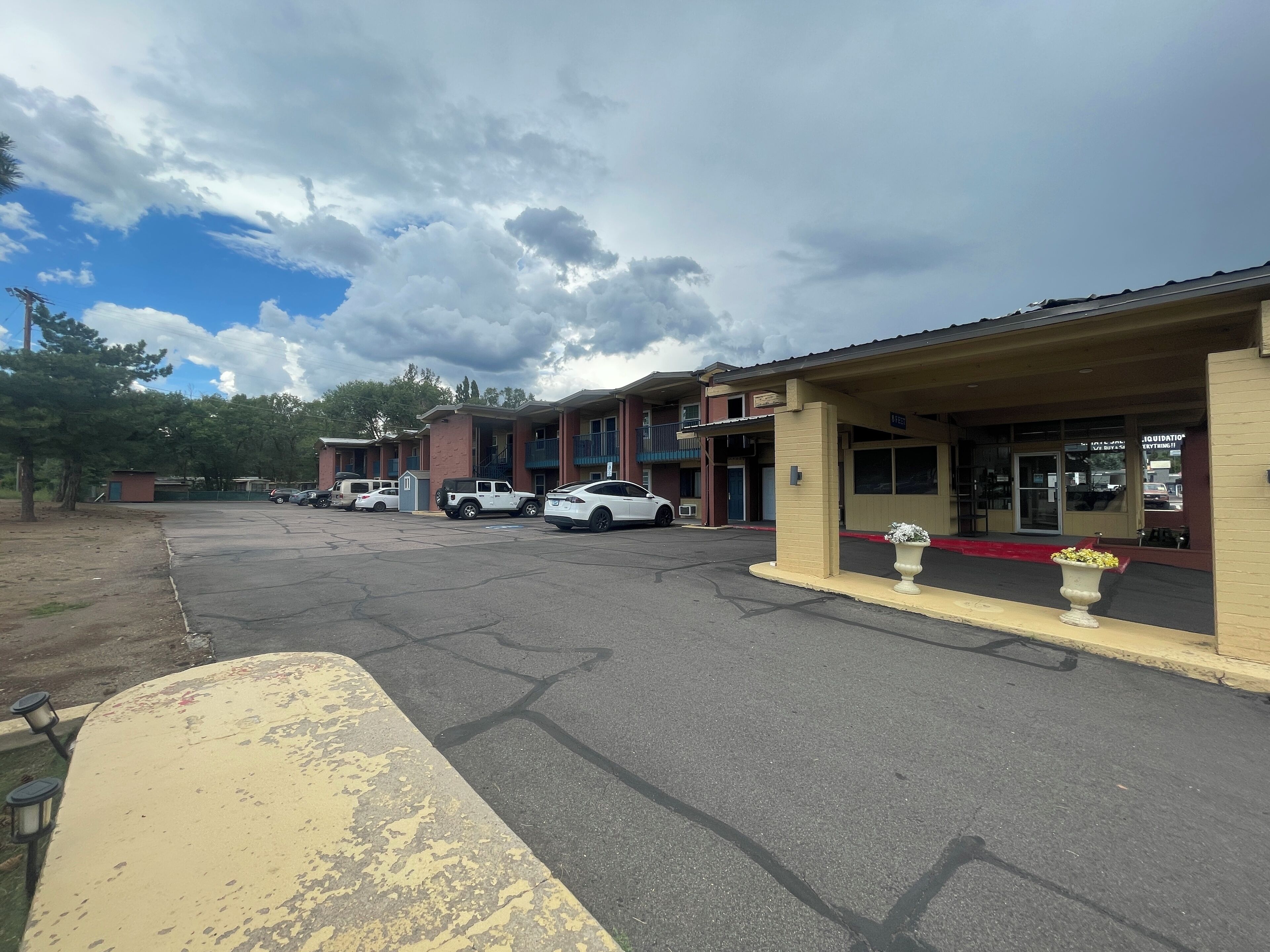 A motel with multiple units, a parking lot, and a small garden area.
