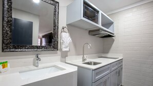 A modern bathroom with two sinks, a mirror, a towel rack, a microwave, and a dish rack. - INN ON 66 (Flagstaff)