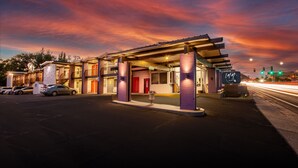 A motel with a covered parking area, multiple rooms, and a street view. - INN ON 66 (Flagstaff)