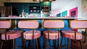 A kitchen with teal cabinets, stainless steel appliances, and pink bar stools. - 9 beauty bars, Photo booth, Karaoke-Girls Getaway steps away from River Street (Savannah)