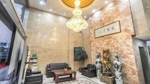 A lobby with a chandelier, sofas, a coffee table, and decorative statues. - Boutique Guodu Hotel (Nantong)