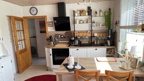 Una cocina moderna con armarios blancos, una mesa de comedor de madera y una alfombra roja.