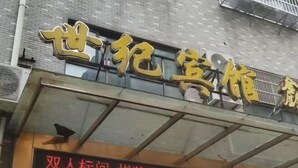 Ein Hotelschild mit chinesischen Schriftzeichen und einer digitalen Anzeige darunter, welche Zimmerpreise und Verfügbarkeit anzeigt.