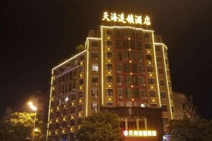 A multi-story hotel with illuminated signage at the top. - Tianhai Yuyuan Hotel (Jiujiang Railway Station) (Jiujiang)
