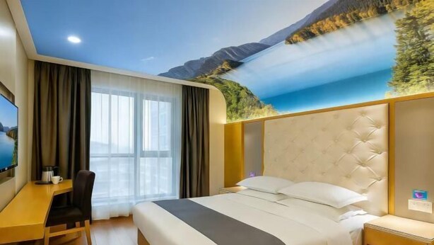 Una habitación de hotel con una cama grande, un escritorio y una silla. Hay un televisor en la pared y una ventana con cortinas.