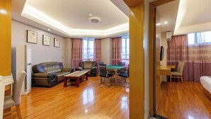 Un amplio salón con sofá, mesa de billar y televisor.