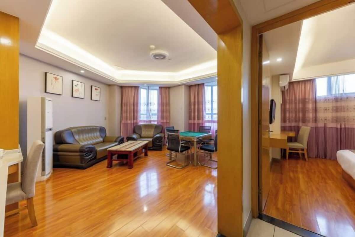 A spacious living area with a sofa, a pool table, and a television.