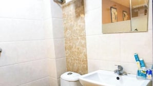 A bathroom with a toilet, sink, and mirror. - Ruida Business Hotel Shenyang (Shenyang)