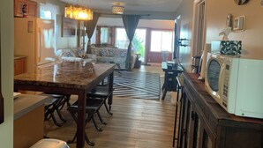 A spacious living area with a large dining table, a kitchen area with a microwave, and a cozy seating area with a sofa and chairs. - "Hook, Line,& Sinker"- At the edge of Erie; 7 days stay plus 1 chartering free
 (Kingsville)