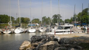 A marina with several sailboats docked, surrounded by rocky terrain and trees. - "Hook, Line,& Sinker"- At the edge of Erie; 7 days stay plus 1 chartering free
 (Kingsville)