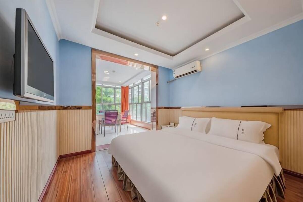 Une chambre à coucher avec un lit, une télévision et une vue sur l’extérieur.