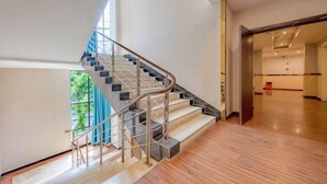 Un intérieur moderne avec un escalier, un plancher en bois et une vue par la fenêtre.