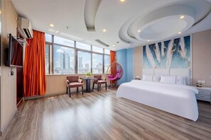 A modern hotel room with a large bed, a city view, a dining area, and a unique ceiling design.