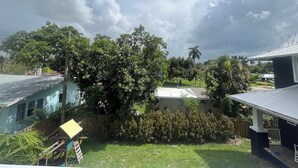 Quintal residencial com deck de madeira, estrutura de recreação infantil e casa com telhado inclinado.