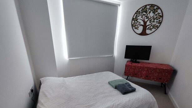 A bedroom with a bed, a desk with a computer, and a wall-mounted tree decoration. -  Spare Bedroom,  Wembley Stadium
 (London)