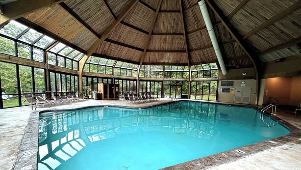 Ein Hallenbad mit hoher Decke und großen Fenstern.