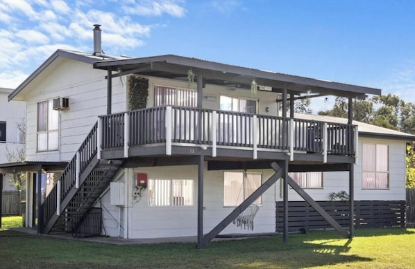 A two-story house with a balcony, a staircase, and a fenced yard.