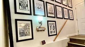 A staircase with a wall decorated with motivational quotes and framed pictures. - Luxury Suite-Unique Quotes Space (Saskatoon)
