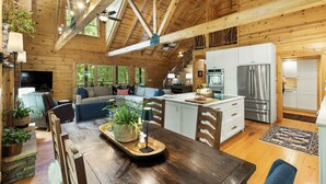 Eine geräumige Holzhütte mit Essbereich, Küche und Wohnzimmer.