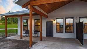 A single-story house with a covered porch, a front door, and two windows. - Pet-Friendly Modern 2BR Duplex in Polson – Walk to Flathead Lake & EV Charging (Polson)