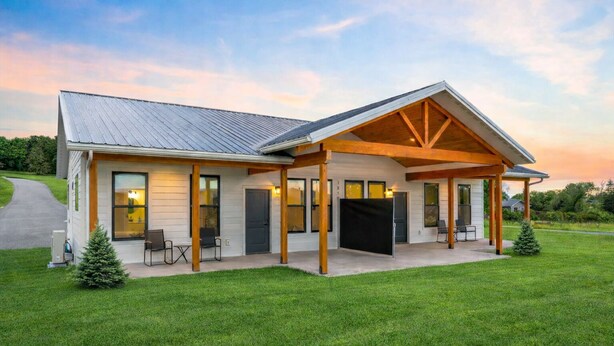 A modern house with a covered porch, a garage, and a well-maintained lawn. - Pet-Friendly Modern 2BR Duplex in Polson – Walk to Flathead Lake & EV Charging (Polson)