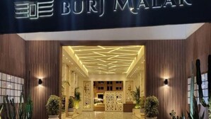 L'entrée du Burj Malak se distingue par son design moderne, avec un plafond aux motifs géométriques et des plantes en pot.