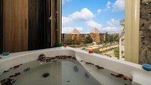 Une salle de bain avec une baignoire, une fenêtre et une vue sur les immeubles.