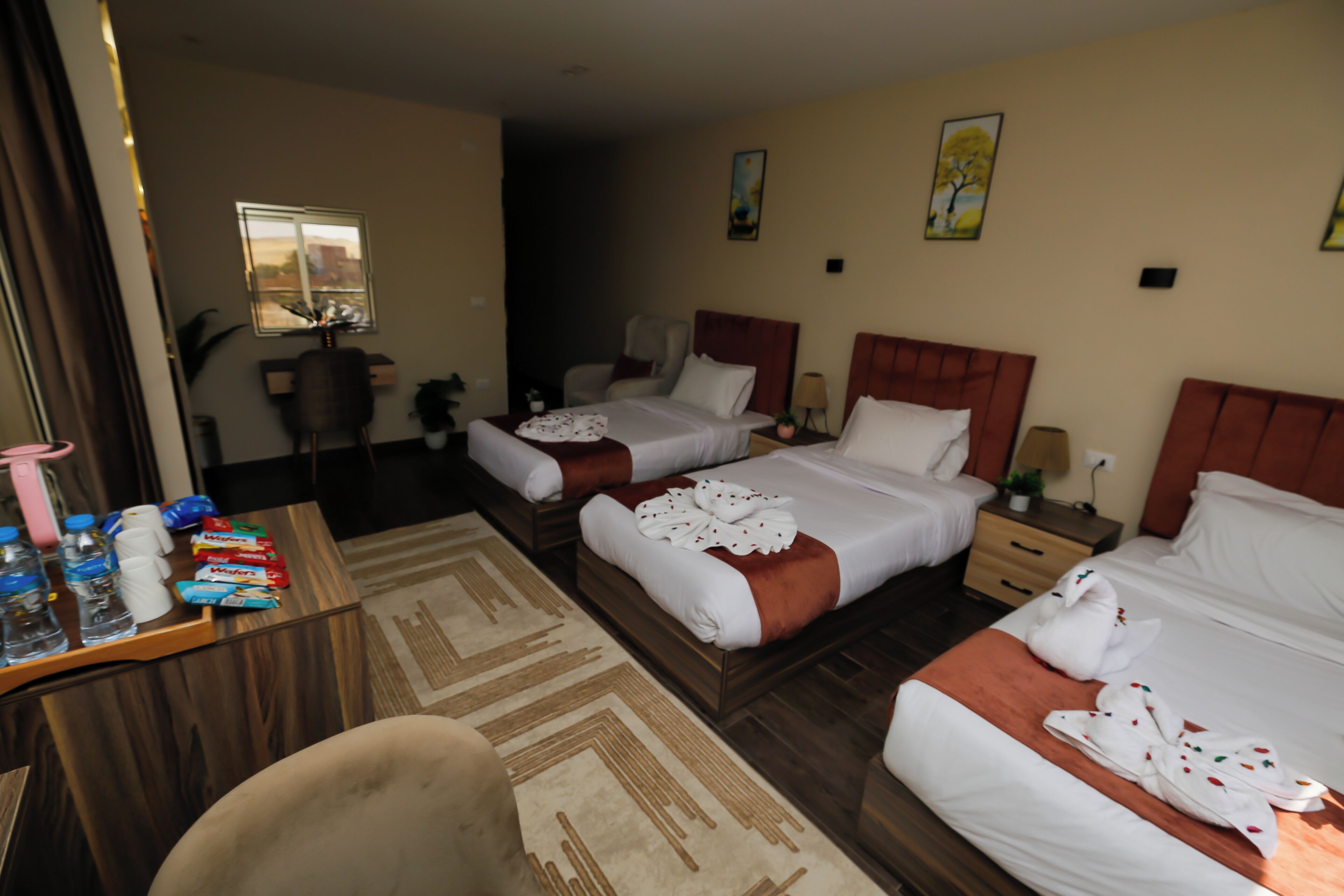 Una habitación de hotel con dos camas, un escritorio con artículos de aseo y una silla.